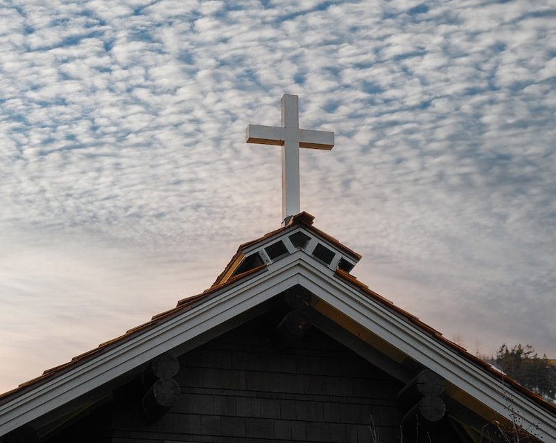 brown and white church under blue sky and white clouds during daytime